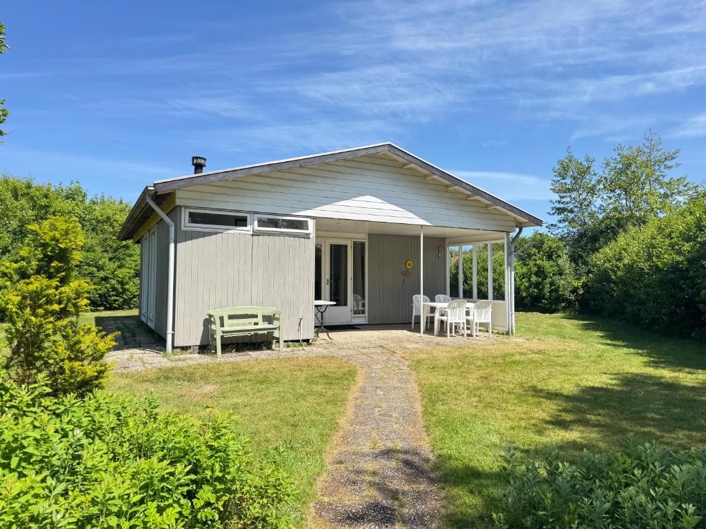 a small shed with a table and chairs in a yard at Keizerskroon 239 in Julianadorp