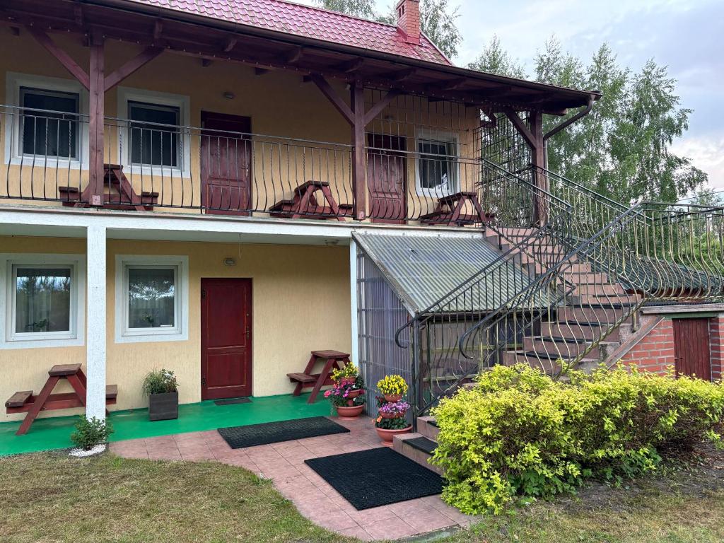 a house with a balcony with a staircase on it at Arkadia - Amber in Jantar