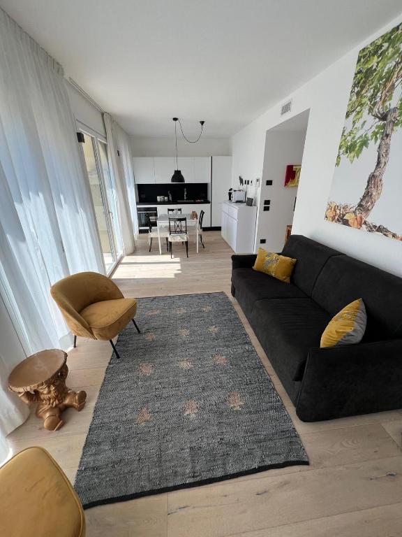 a living room with a black couch and a rug at Junior Suite agli Archetti in Torri del Benaco