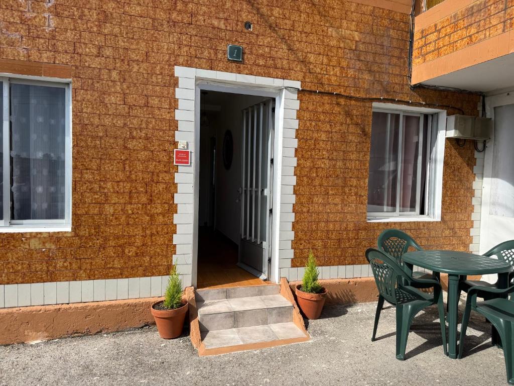 a patio with a table and chairs and a door at La casita de llanda in Suances