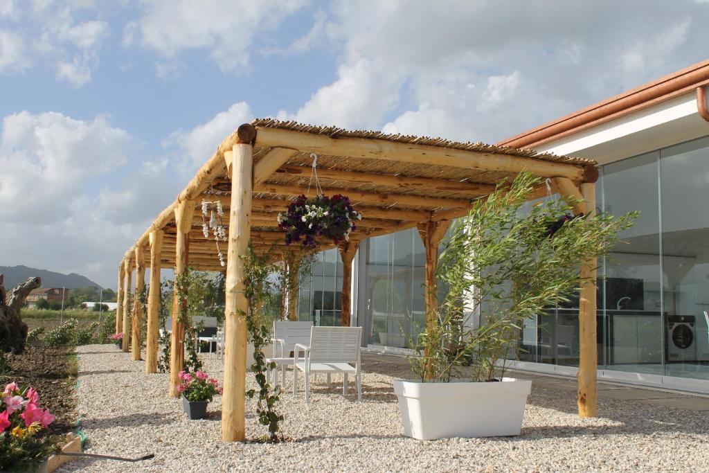 a wooden pergola with a table and chairs and plants at Tenuta Mari in Castelnuovo Cilento