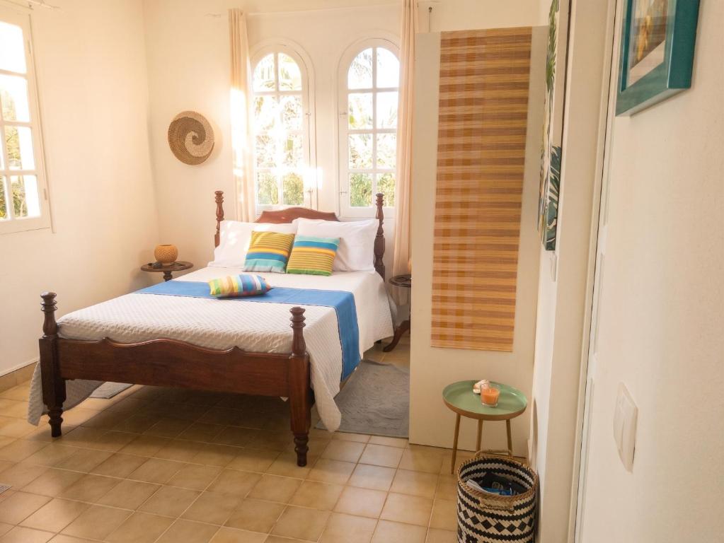 a bedroom with a bed and two windows at Studio accueillant à Baie Mahault - 20 m² avec piscine privée in Baie-Mahault