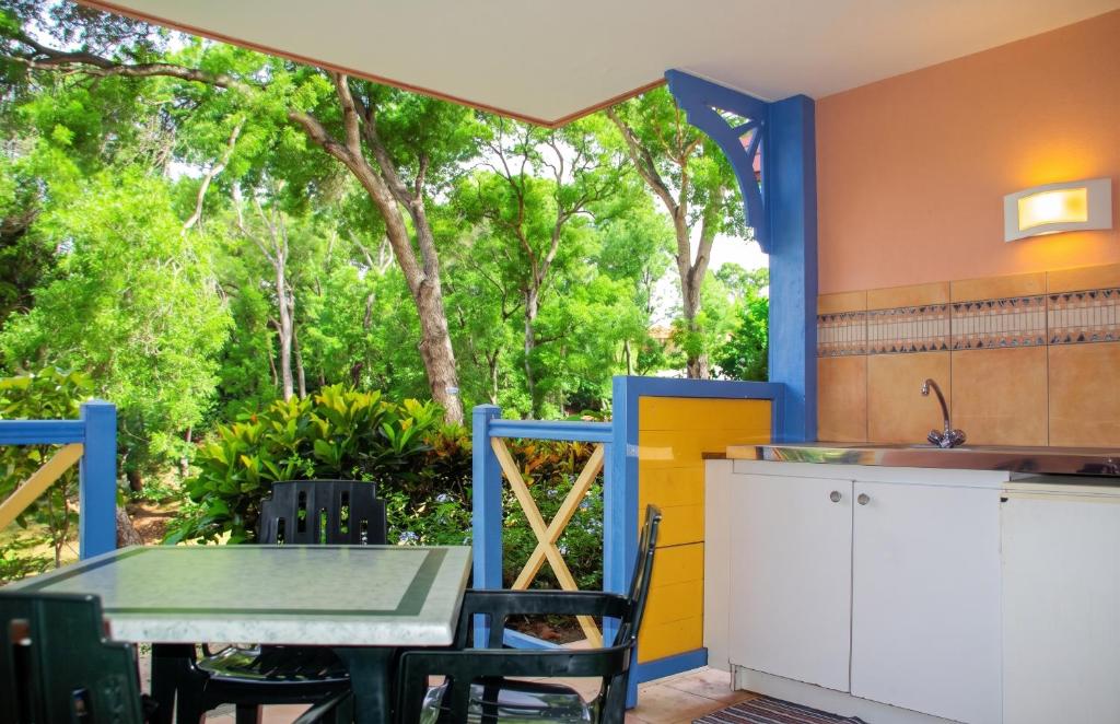 an outdoor kitchen with a table and a sink at Studio chaleureux à Sainte-Anne - 29m² avec jardin. in Sainte-Anne