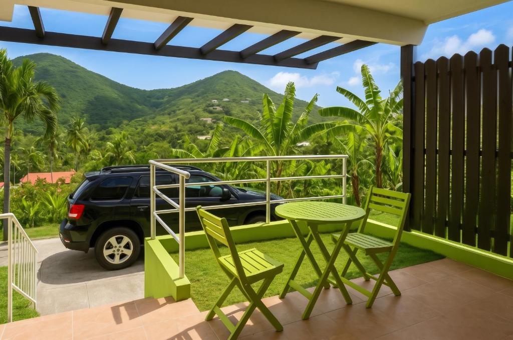 a table and chairs on a patio with a view of mountains at Charming Apartment in La Savane, 65 sqm with Terrace in Happy Bay