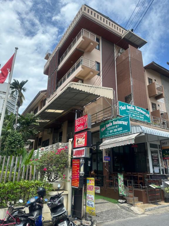 a motorcycle parked in front of a building with signs at Smile Home in Patong Beach