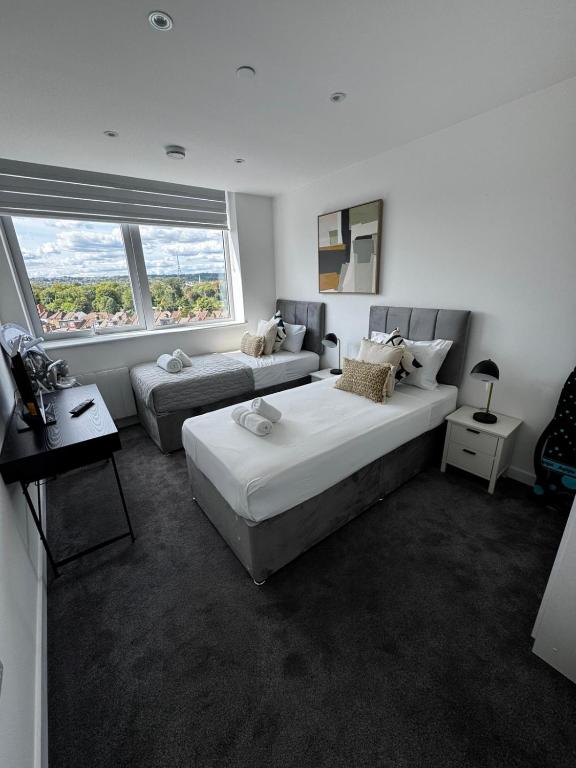 a white room with two beds and a couch at Stylish 1BR with Comfy Vibes in Beckenham