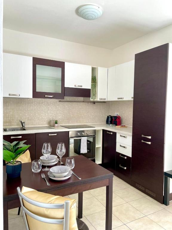 a kitchen with a table with wine glasses on it at Monolocale moderno - Colazione Inclusa in Vimodrone