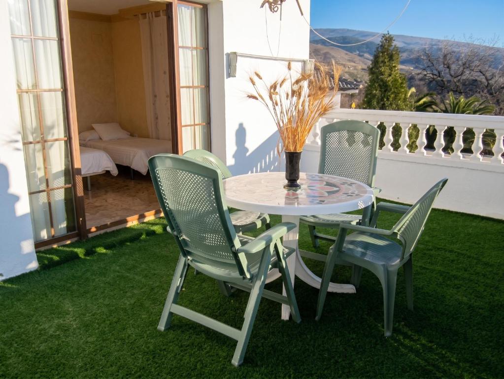 a patio with a table and chairs on the grass at Idyllic House in Yegen with Mountain View in Yegen