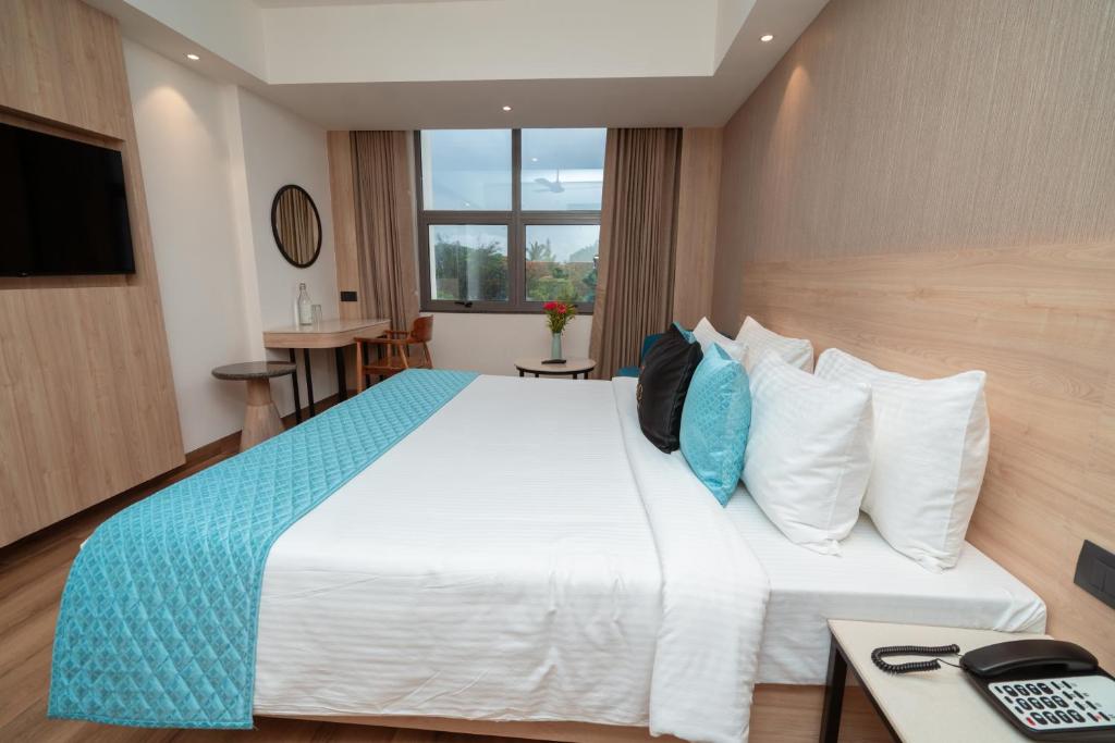 a hotel room with a large bed and a television at Metro park inn in Coimbatore