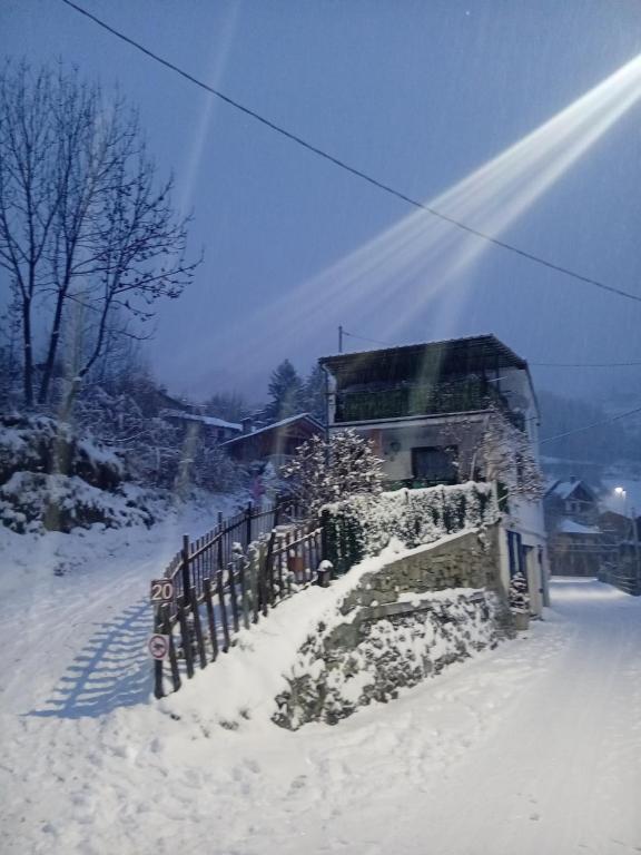 a building in the snow next to a fence at Alloggio Centro Torgnon vicino impianti sci in Torgnon