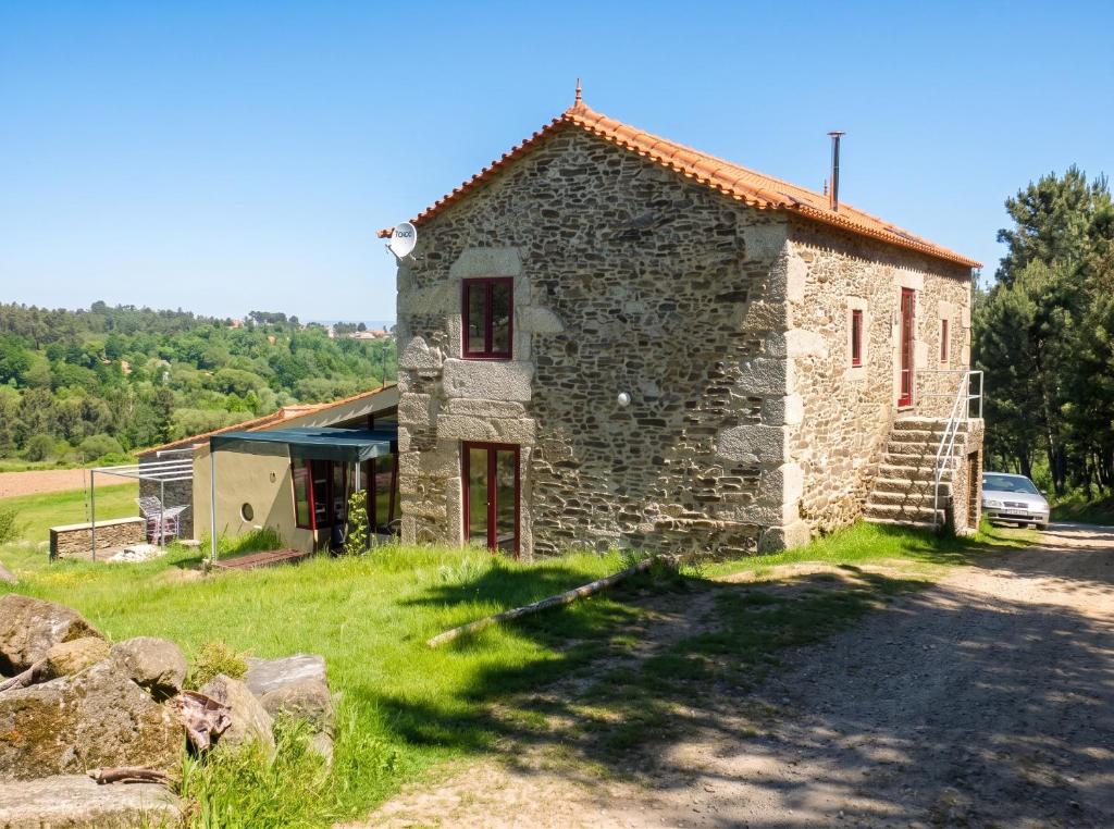 an old stone house with a car parked next to it at Spacious House in Seia with Stunning Mountain Views, 150 m² in Seia