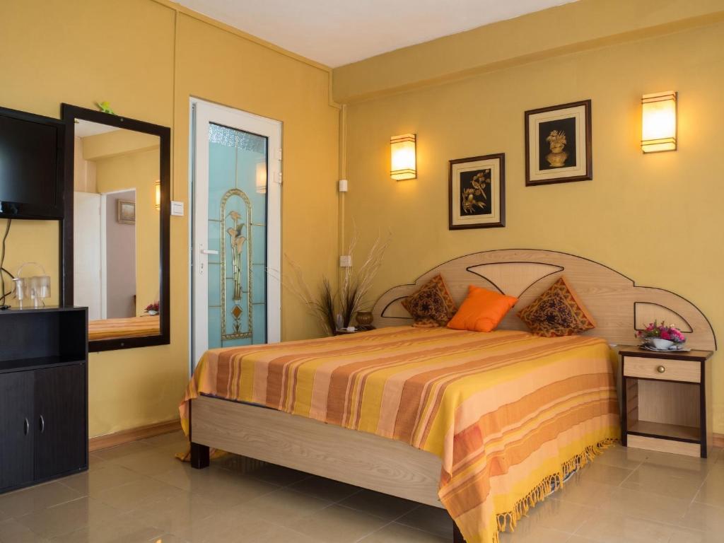a bedroom with a bed and a dresser and a mirror at Charming Apartment in Pamplemousses, 30 m² with Garden View in Pamplemousses Village