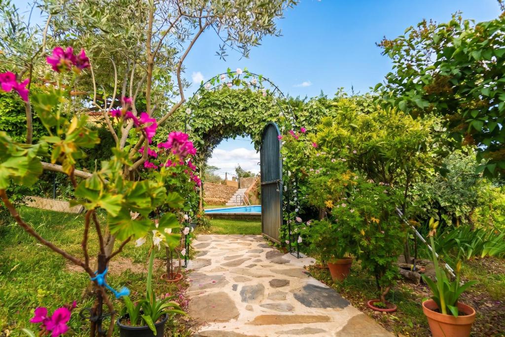 an archway in a garden with flowers at Cozy studio in Valencia de Alcántara 25 m² lovely garden in Valencia de Alcántara
