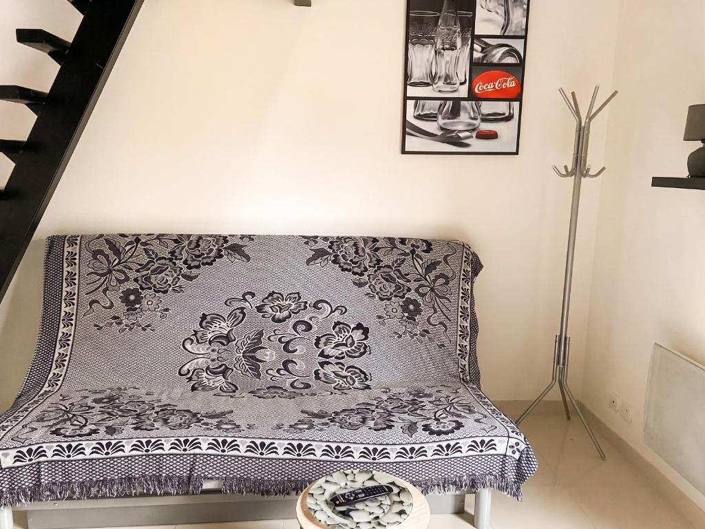 a couch sitting in a living room next to a staircase at Charmant studio avec terrasse à Chenou, 20 m² in Chenou