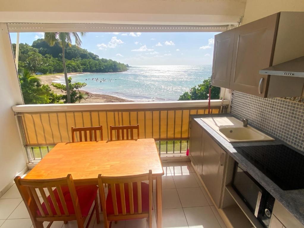 a kitchen with a table and a view of the ocean at Studio confortable avec vue sur la mer in Le Gosier