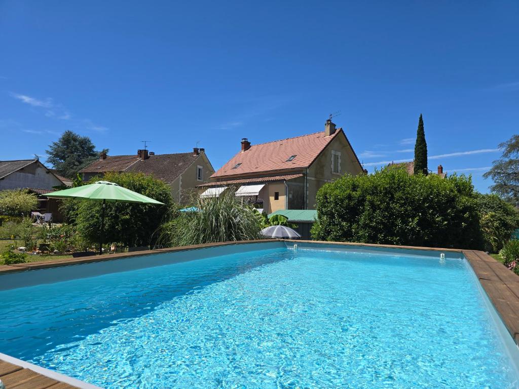 a swimming pool in front of a house at Chambres d'hôtes Ecole Buissonnière en Dordogne in Le Buisson de Cadouin