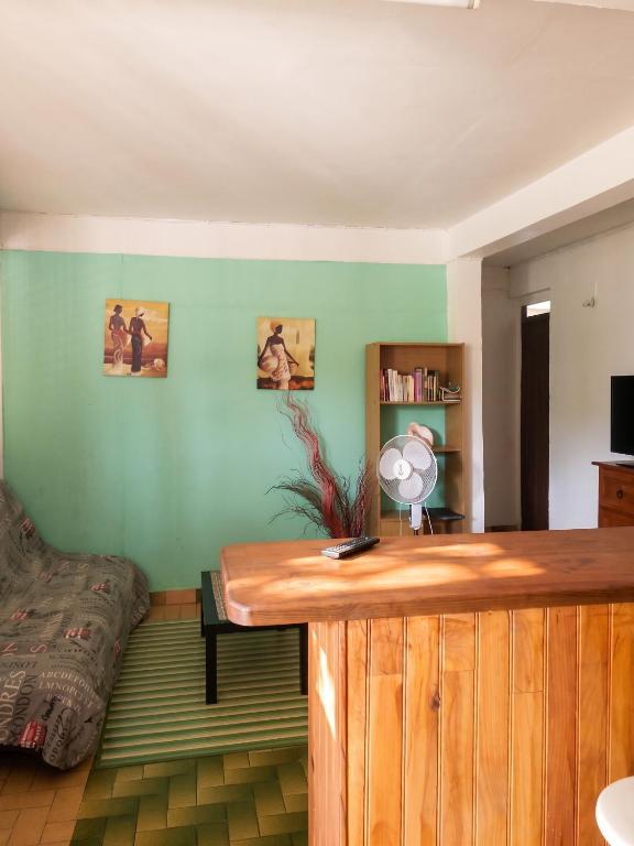 a room with a bed and a wooden desk at Appartement confortable à Sainte-Anne, 70m², vue jardin in Sainte-Anne
