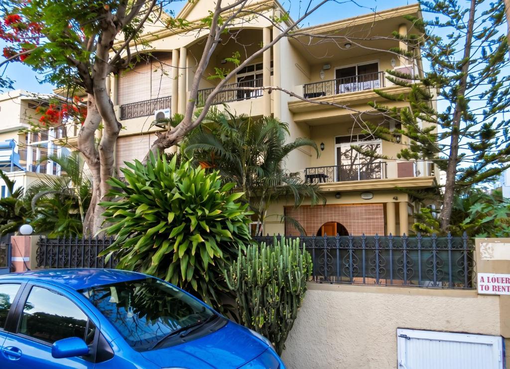 a blue car parked in front of a building at Cozy studio in Trou-aux-Biches 35 m² with lovely garden balcony in Trou aux Biches