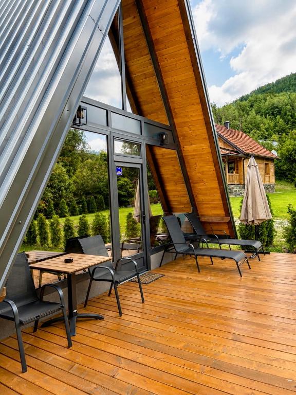 a patio with chairs and a table on a wooden deck at Terra Ruj in Mokra Gora