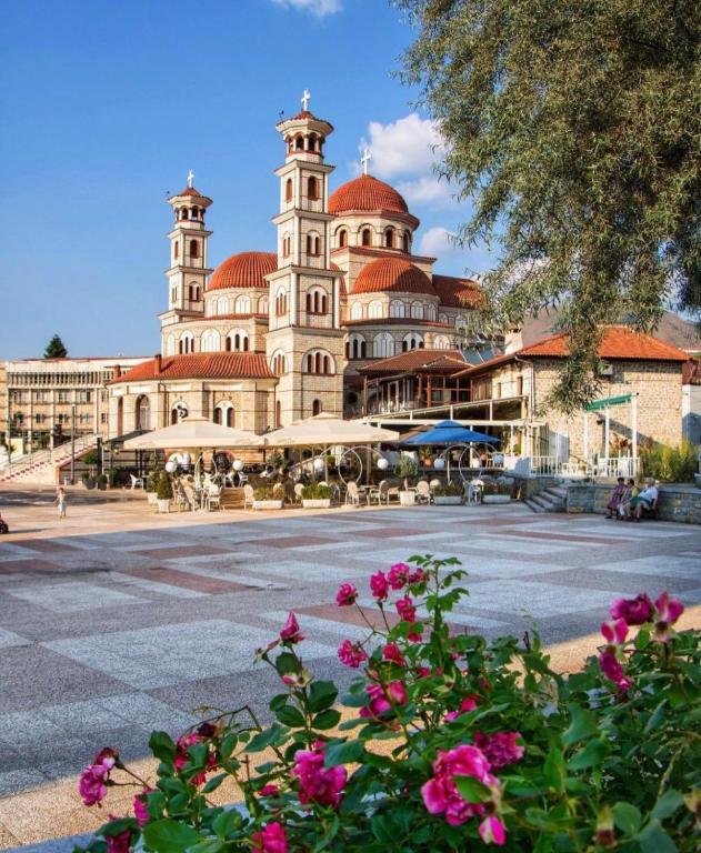 a large building with pink flowers in front of it at Za Apartment 2 in Korçë