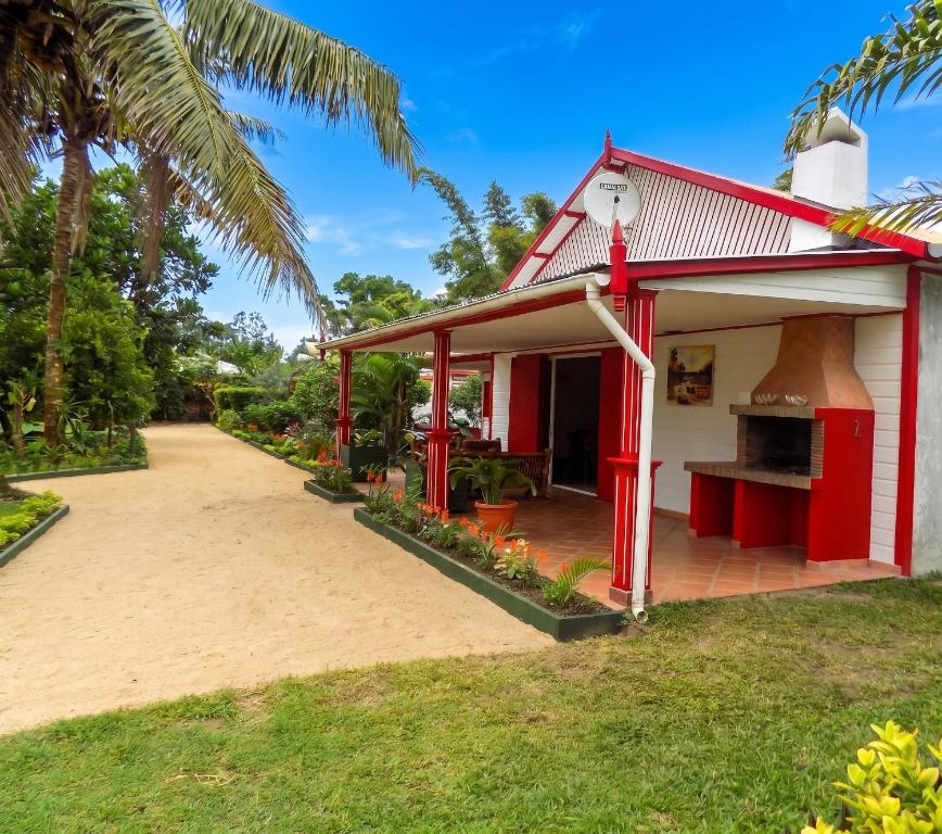 a red and white house with a driveway at Charming Studio in Foulpointe, Sea View and Garden, 30 m² in Foulpointe