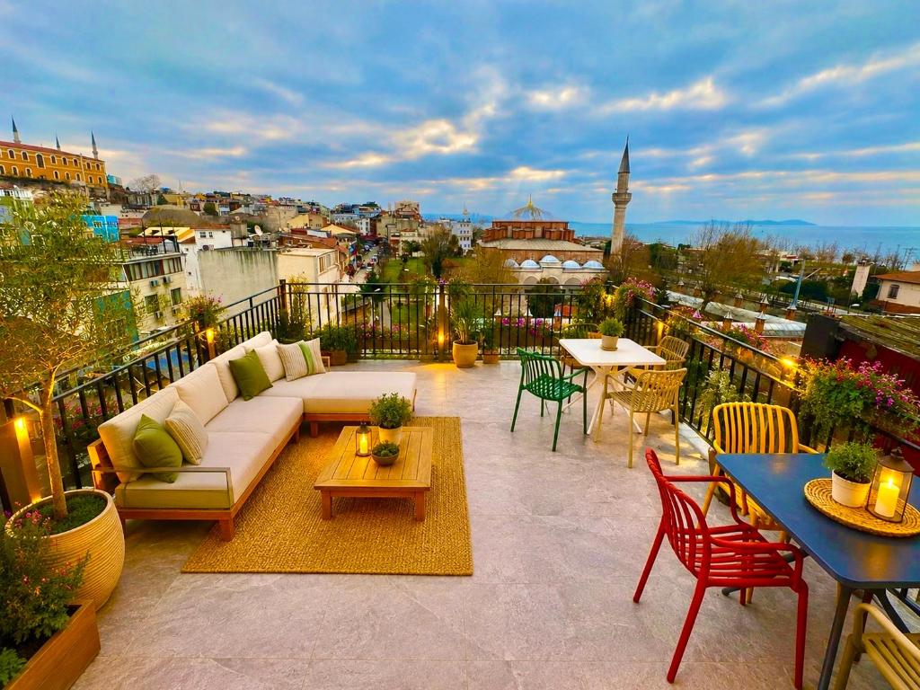 a rooftop patio with a couch and tables and chairs at Hagia Sophia Palace Hotel in Istanbul