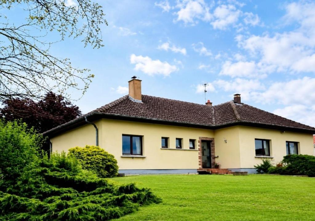 a large yellow house with a green lawn at Gite Les Ptits Biscuits in Vittersbourg
