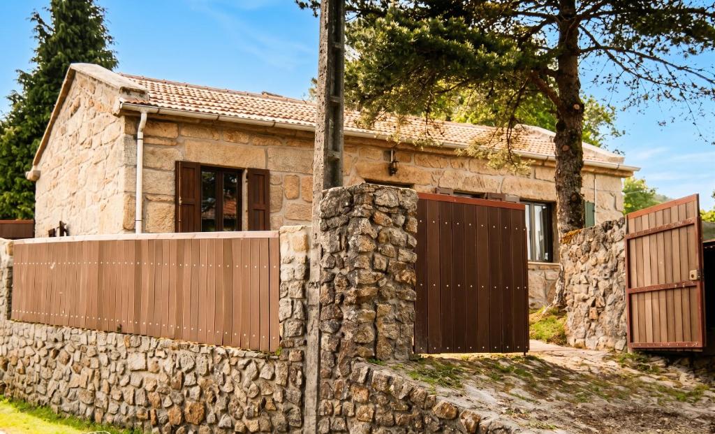 a stone house with a gate and a stone wall at Charming House in Sistelo + View in Sistelo