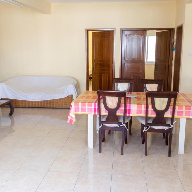 a dining room with a table and chairs and a bed at Elegant Apartment in Trou aux Biches / 125 m² / Mountain View in Trou aux Biches
