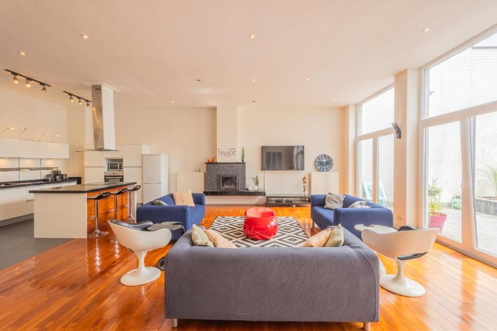 a living room with a blue couch and chairs at Spacious House with Large Garden in Jette in Brussels