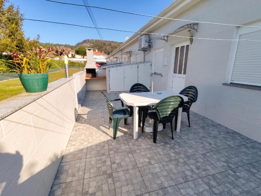 a patio with a table and chairs on a balcony at Comfortable House in Marinhas + Garden and Sea View. in Marinhas