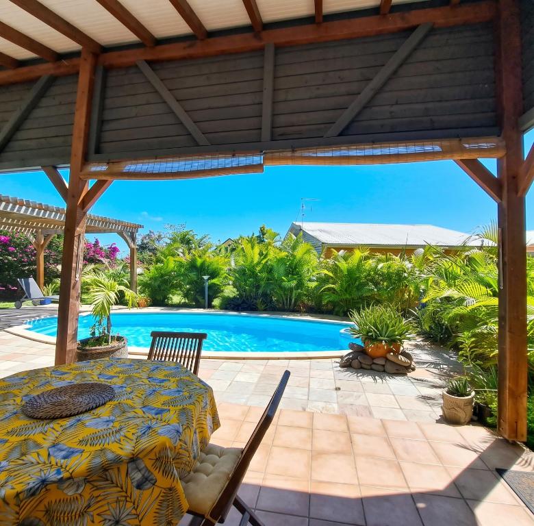 a patio with a table and a swimming pool at Villa cosy avec piscine privée - Le Gosier. in Le Gosier