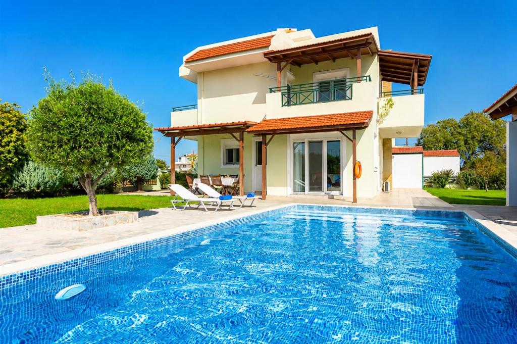 a villa with a swimming pool and a house at Hermione Villa in Gennadi