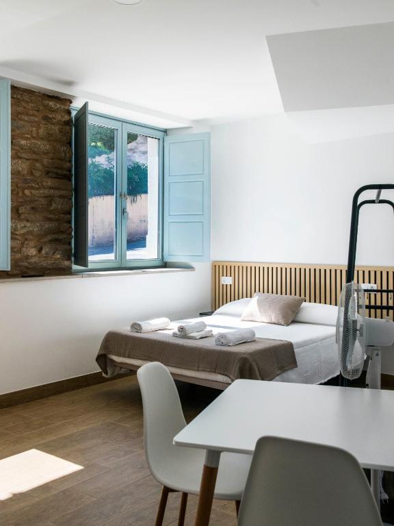 a room with two beds and a table and chairs at A Calexa Sarria nº1 in Sarria