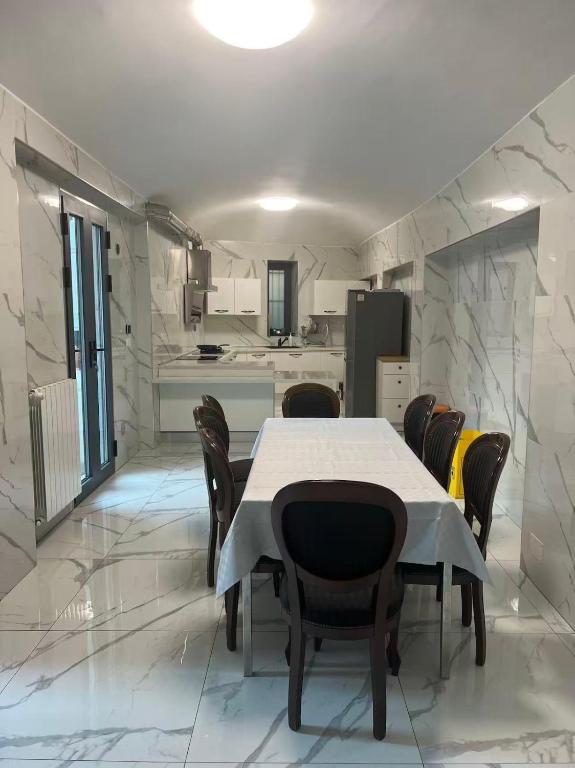 a dining room with a table and chairs and a kitchen at Casaxxvaprile in Turin
