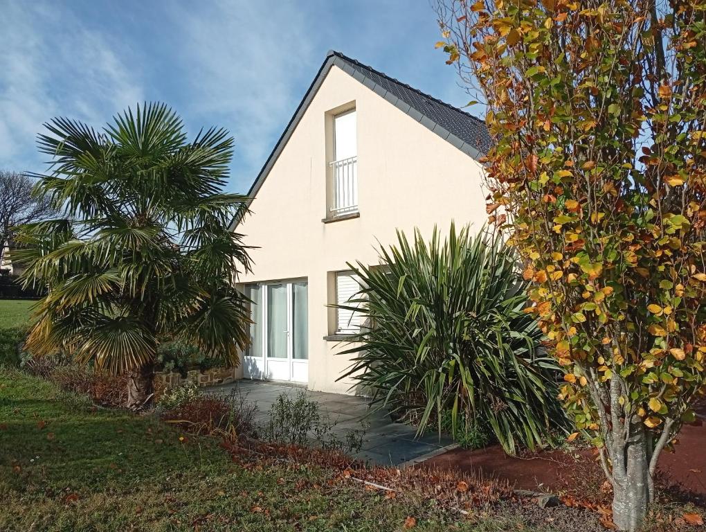 a white house with two palm trees in front of it at La Tantonnière in Romagny