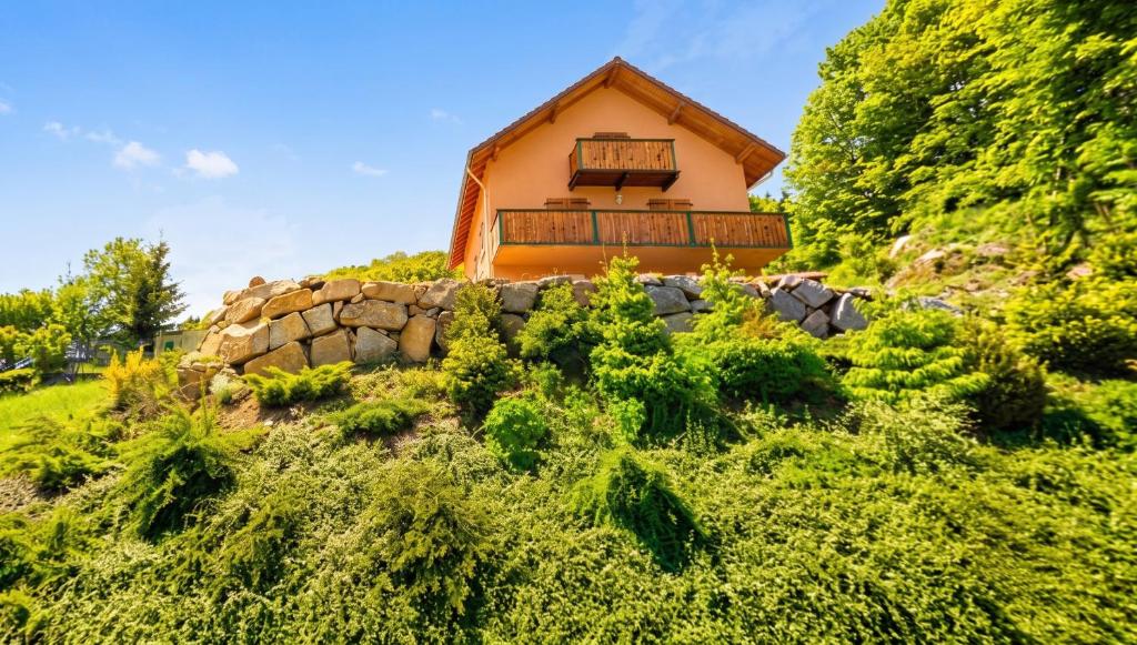 a house on a hill with a stone wall at Appartement confortable à Cornimont 30 m² vue montagne in Cornimont