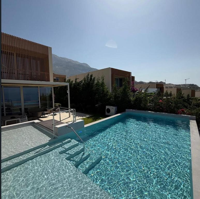 a swimming pool with lounge chairs in a building at Vila IL SOLE GREEN COAST in Palasë