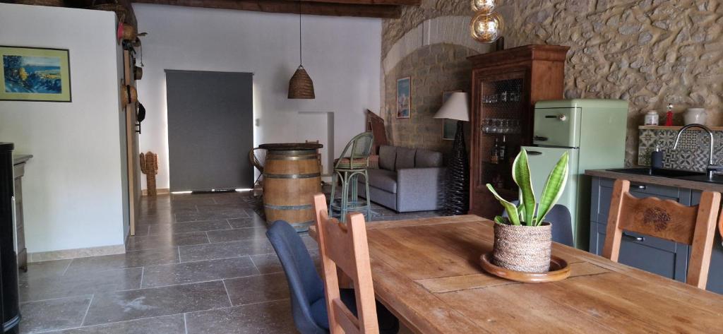 a kitchen with a wooden table with a plant on it at La Remise in Vergèze