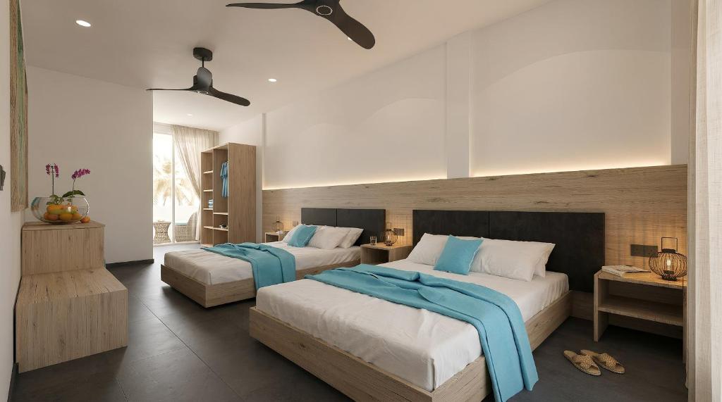 a bedroom with two beds with blue sheets at Nala Inn in Fulidhoo