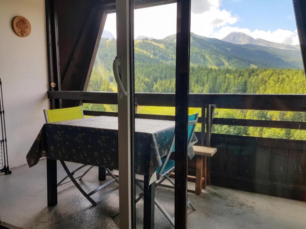 a table and a chair in a room with a view at Studio avec vue sur la montagne à Villard de Lans - 34 m² in Villard-de-Lans