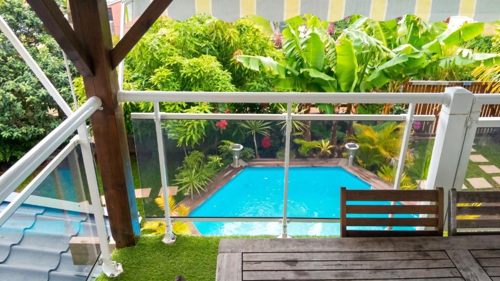a view from the balcony of a villa with a swimming pool at Maison cosy avec piscine partagée à Capesterre-Belle-Eau in Besnard