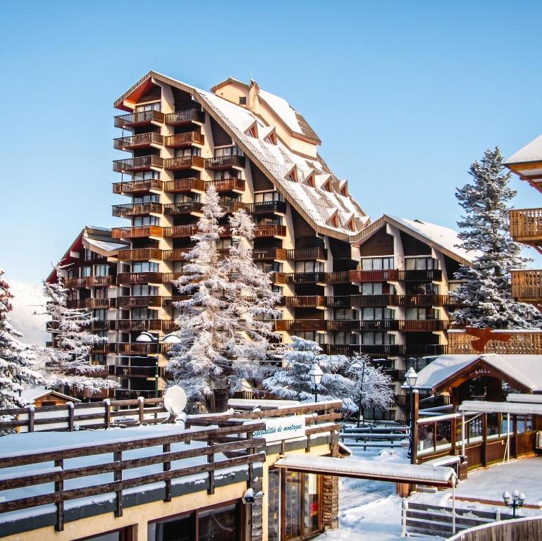 a large apartment building with a snow covered roof at Studio chaleureux à Uvernet-Fours, 25m² avec vue montagne in Uvernet