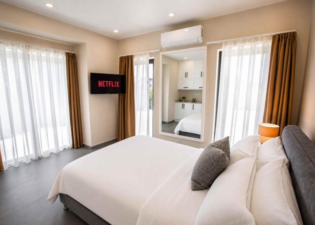 a bedroom with a large white bed with a mirror at Grey Stones Villa by HolidayKeys in Kyrenia