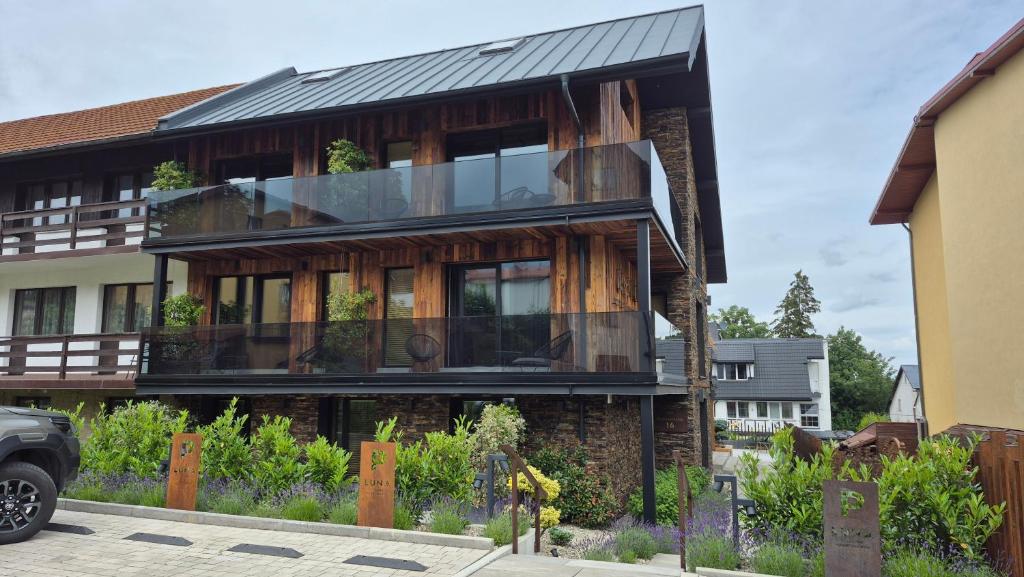 a house with a balcony on the side of it at LUNA Luxury Apartments - Adults Only - sauna, jacuzzi in Szklarska Poręba