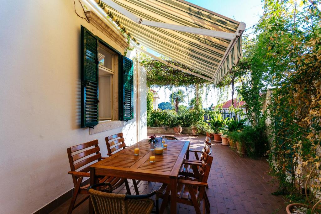 einen Holztisch und Stühle auf einer Terrasse in der Unterkunft Apartment Thalassicus A27 in Dubrovnik