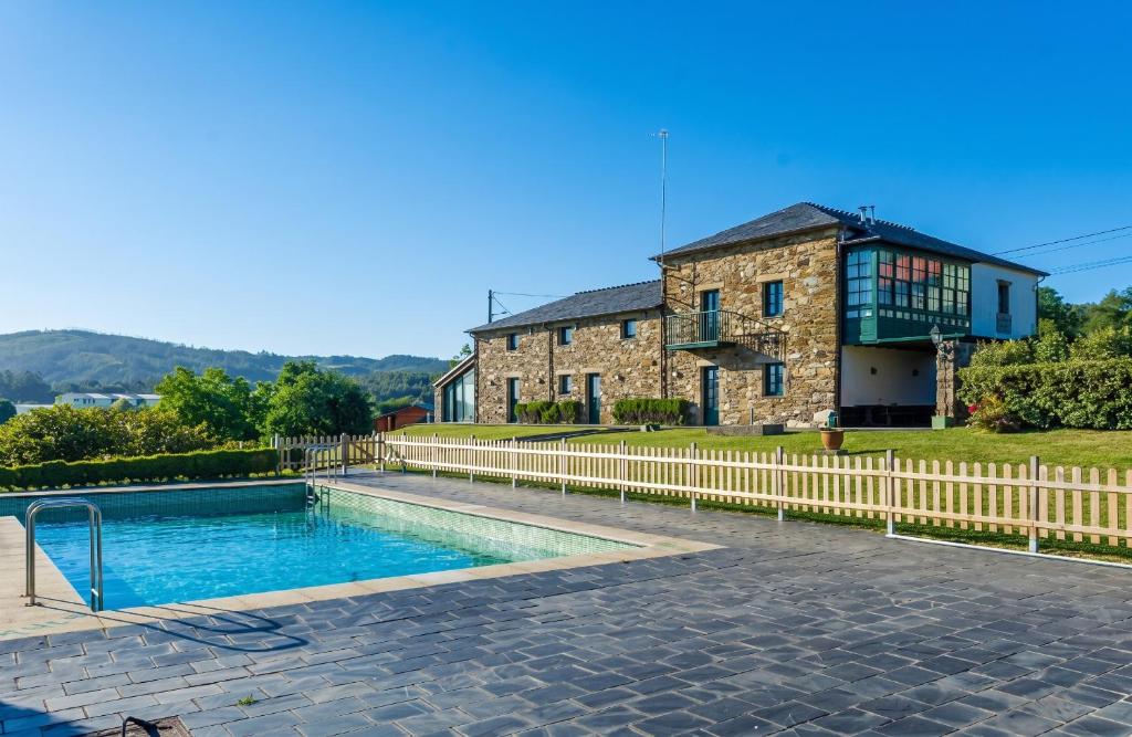 a house with a swimming pool in front of a building at Luxurious Villa in Outeiro - Private Pool in Santa María La Mayor del Rosario