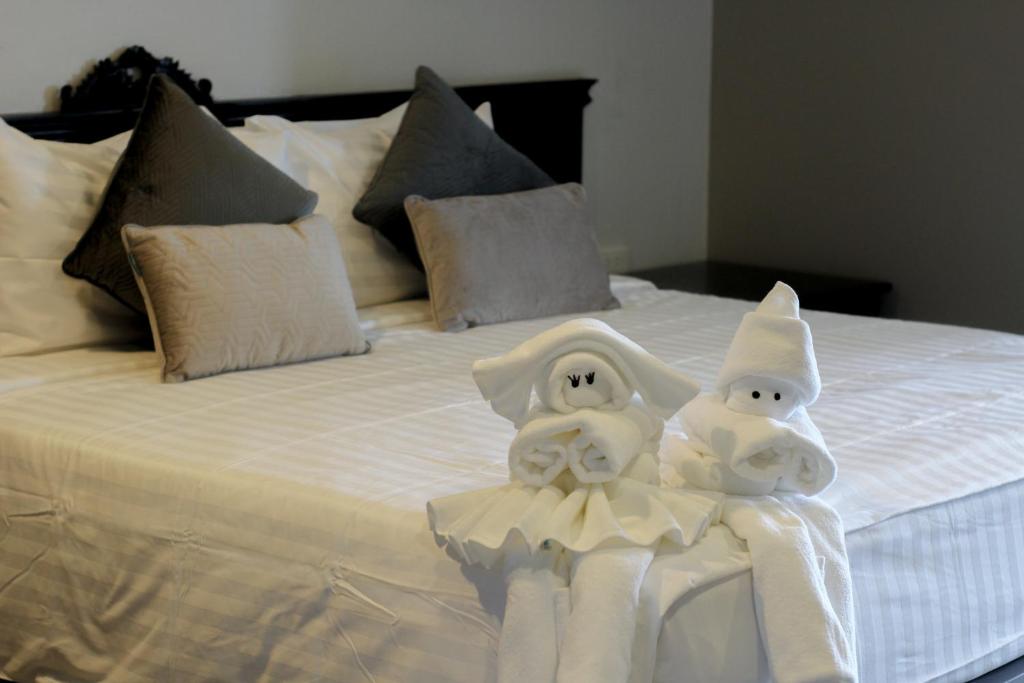 two towels are made to look like penguins on a bed at Hotel De Kiang Muang in Chiang Mai