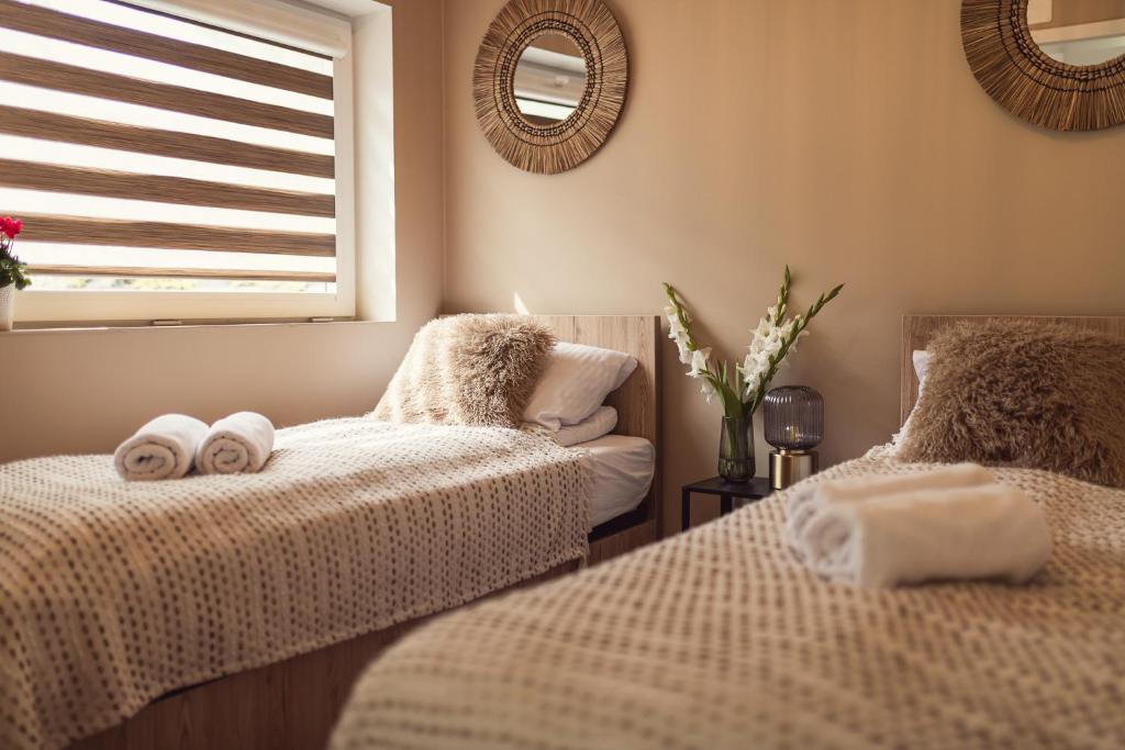 two beds in a bedroom with towels on them at Domki pod Krakowem - Stare Sady in Kopytówka