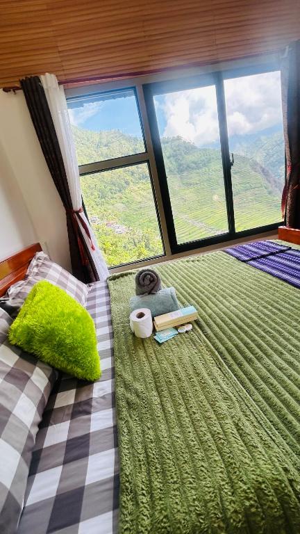 a bedroom with a bed and a large window at Batad Pension Ph in Banaue